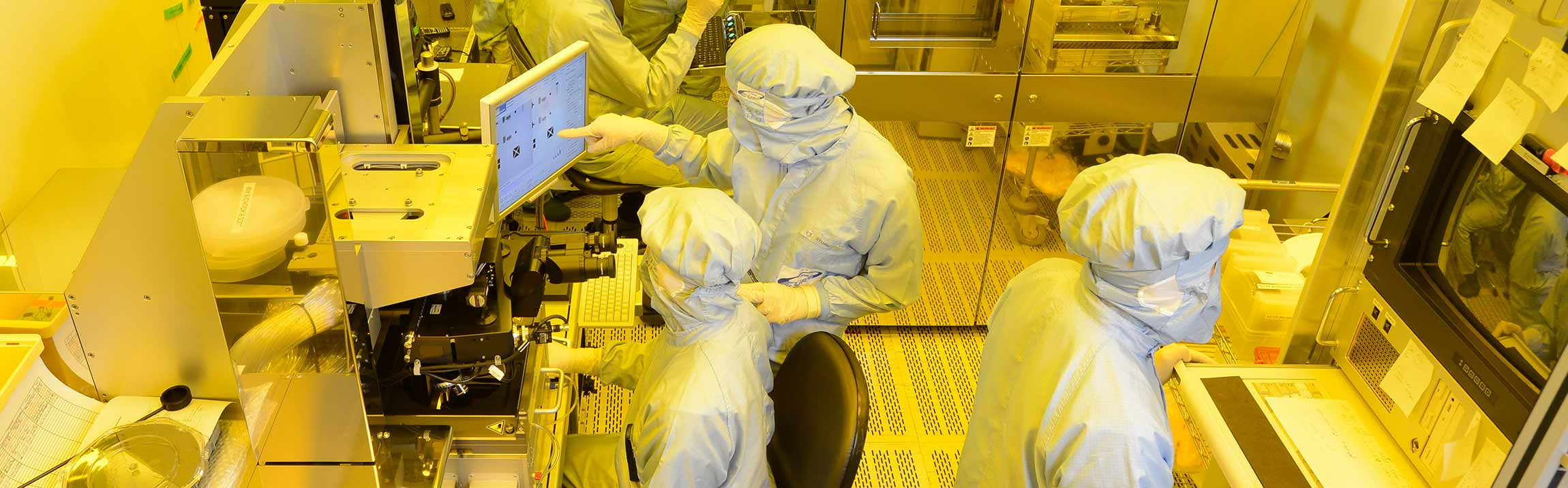 Fraunhofer EMFT employees in a clean room for microsystems technology and sensor technology